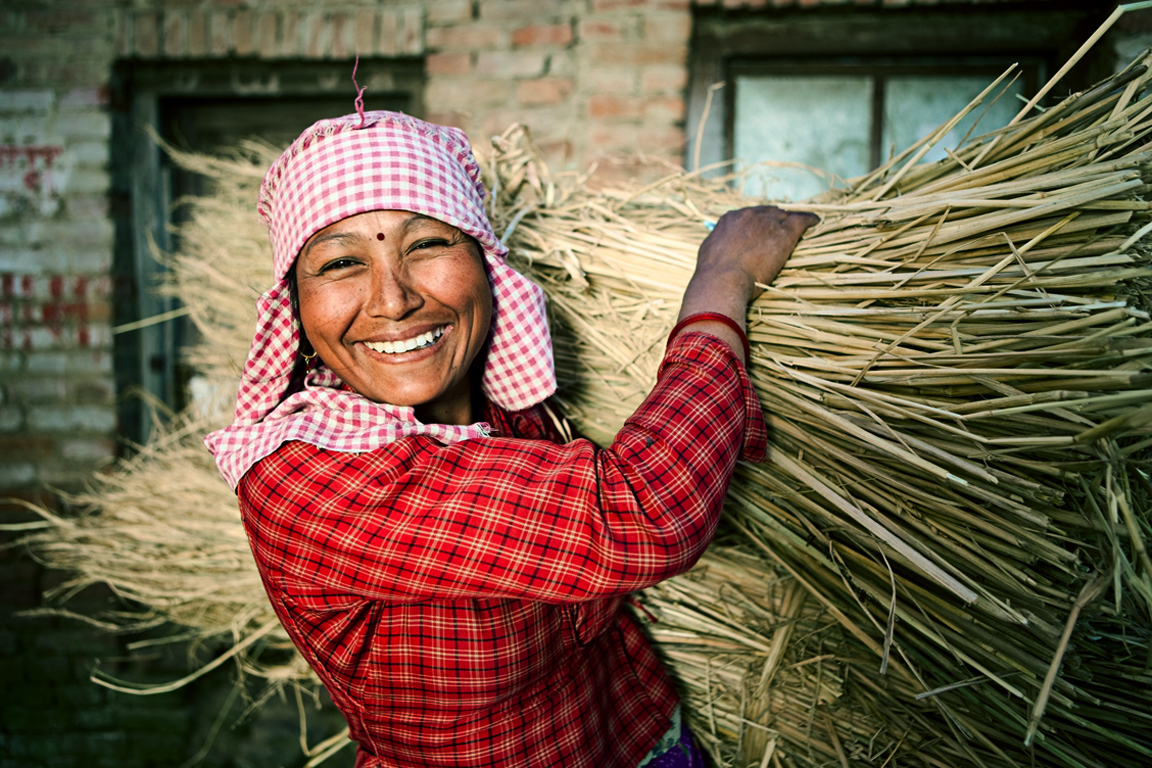 Nepali woman Nepali woman smiling while carrying straw.