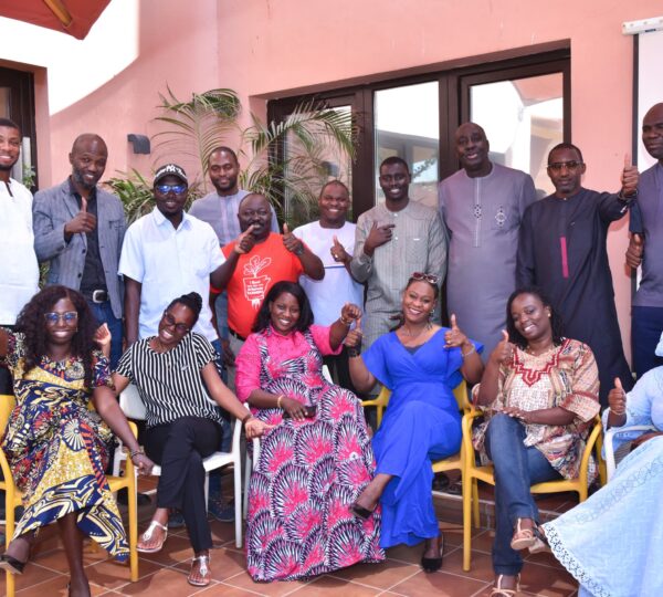 Group photo of Senegalese Heifer employees wearing traditional clothes that smile at the camera